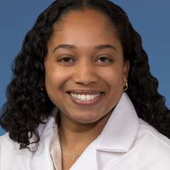 Head shot of Rehana Persaud, MD, MS in white coat, smiling at the camera