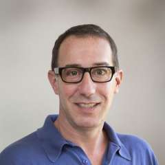 David Eisenman, MD headshot wearing glasses and blue shirt, smiling