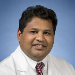 Raman Muthusamy, MD, MAS headshot wearing white coat and tie, smiling