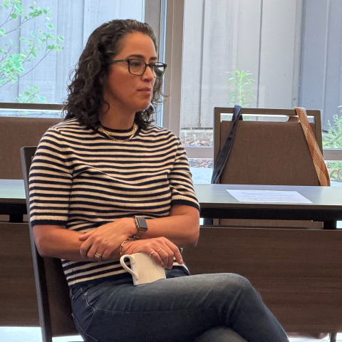 A seated doctor speaks at a conference.